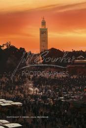 Image du Maroc Professionnelle de  Au coucher du soleil et même un peu avant la foule envahi la fameuse Place Jemaa El Fana qui se métamorphose en un gigantesque restaurant en plein air grâce aux nombreux stands et gargotes qui s'y installent sur ce lieu mythique au centre de la médina de Marrakech. Au fond le minaret de la Koutoubia, Samedi 26 Février 2005. (Photo / Abdeljalil Bounhar)

